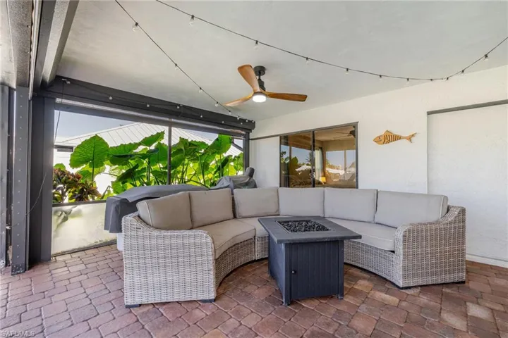 View of patio featuring an outdoor living space with a fire pit and a ceiling fan