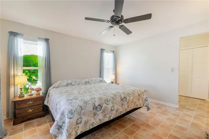 Bedroom with light tile patterned floors and a ceiling fan