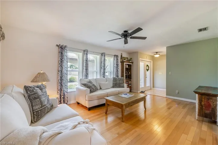 Living room with light wood-type flooring and a ceiling fan