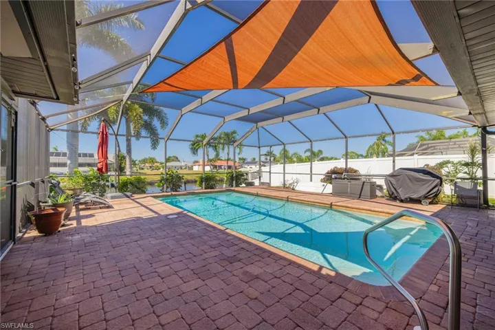 View of pool featuring a patio, a sunroom, area for grilling, and a lanai