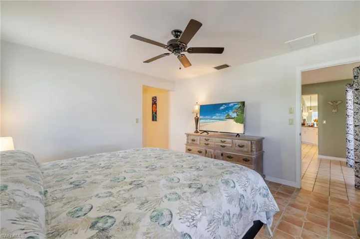 Bedroom with light tile patterned floors and ceiling fan
