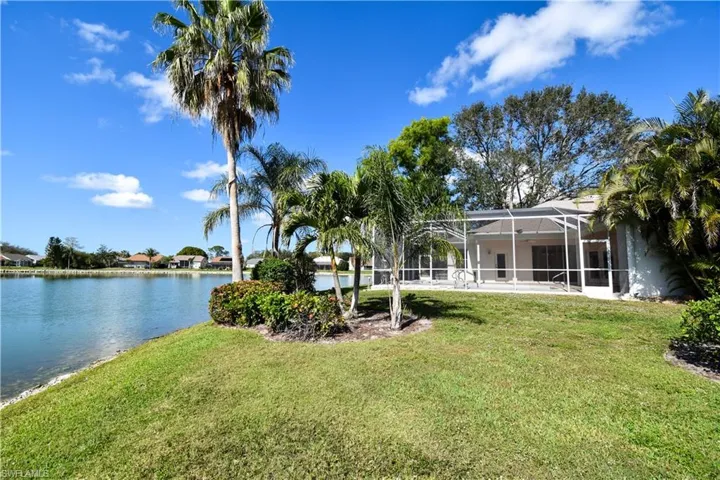 View of yard with a lanai and a water view