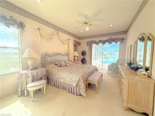 Carpeted bedroom with multiple windows, access to exterior, and ceiling fan