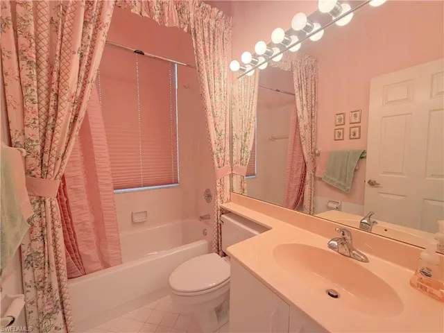 Full bathroom featuring vanity, shower / tub combo, tile patterned floors, and toilet