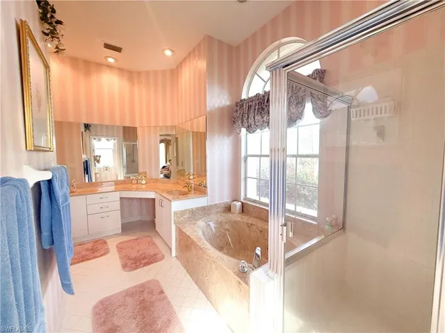 Bathroom featuring vanity, separate shower and tub, and tile patterned floors