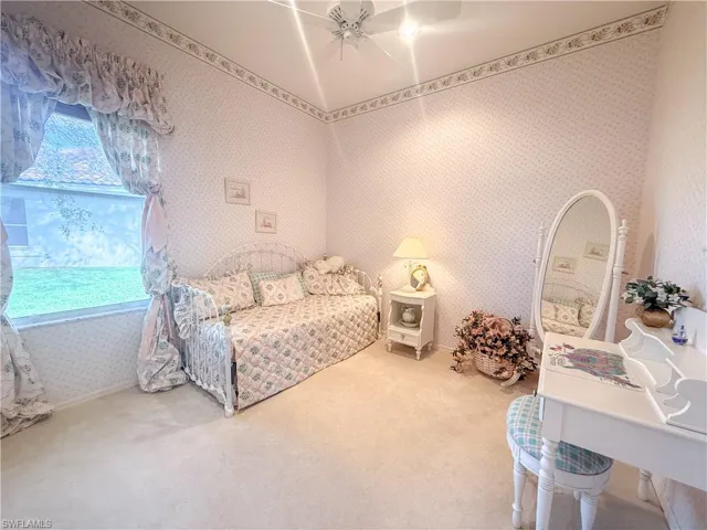 Bedroom featuring multiple windows, ceiling fan, and carpet flooring