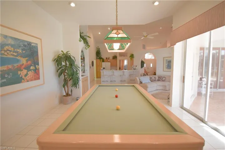 Recreation room with light tile patterned floors, billiards, and ceiling fan