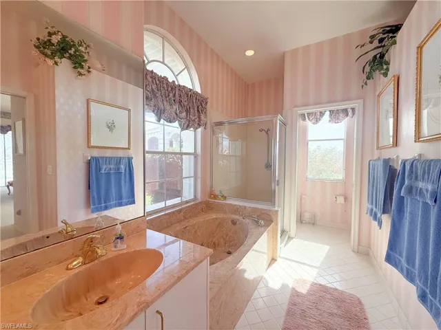 Full bathroom featuring vanity, a fireplace, tile patterned floors, shower with separate bathtub, and toilet