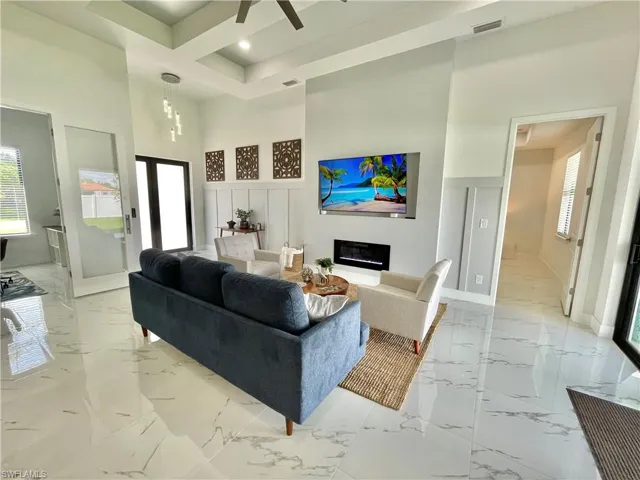 Living room featuring ceiling fan and a towering ceiling