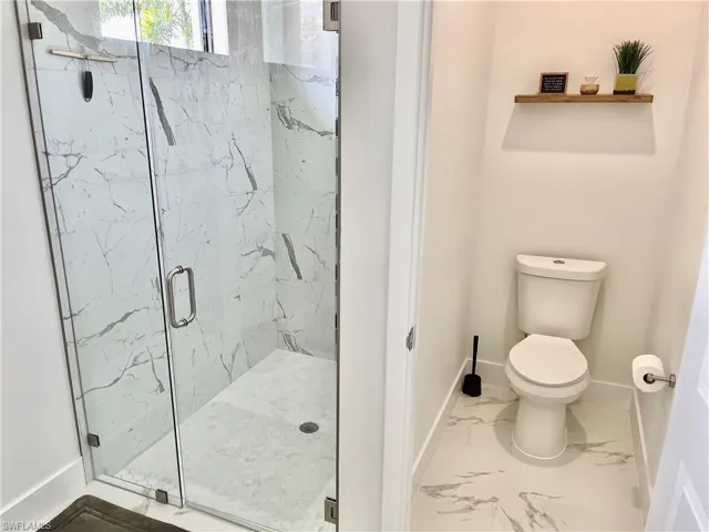 Bathroom with toilet and a shower with shower door