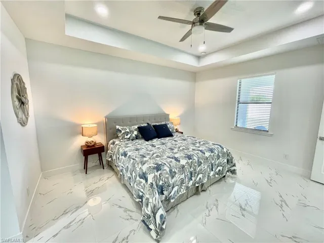 Bedroom with ceiling fan and a tray ceiling