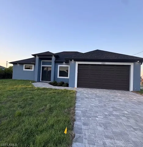 Prairie-style home featuring a garage and a yard