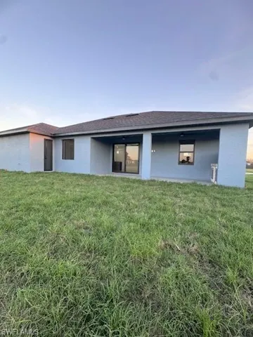 Back of property featuring a yard