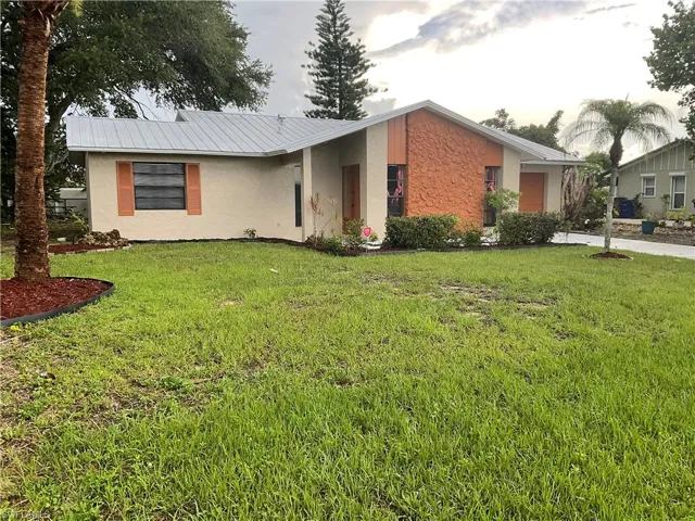 Ranch-style home featuring a front lawn