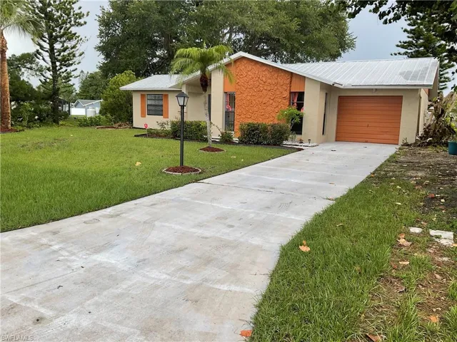 Single story home featuring a front lawn and a garage