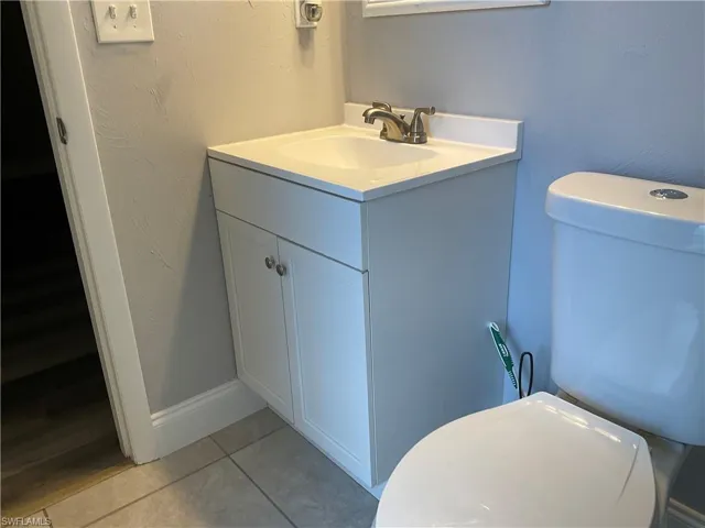 Bathroom featuring tile floors, toilet, and vanity