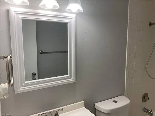 Bathroom with tiled shower / bath and toilet