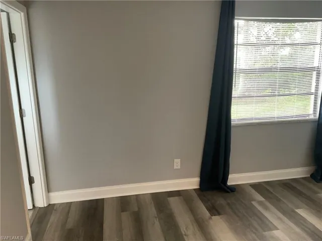 Empty room featuring dark wood-type flooring