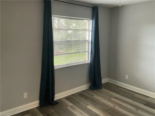 Empty room with dark hardwood / wood-style floors