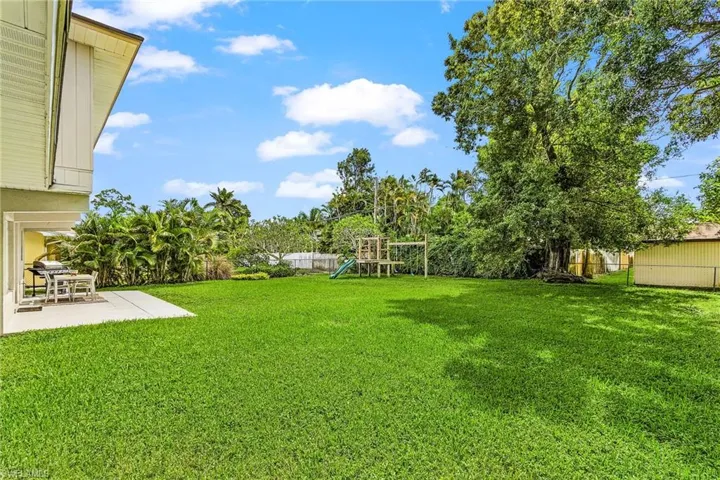 Fenced backyard with a playground and a patio area