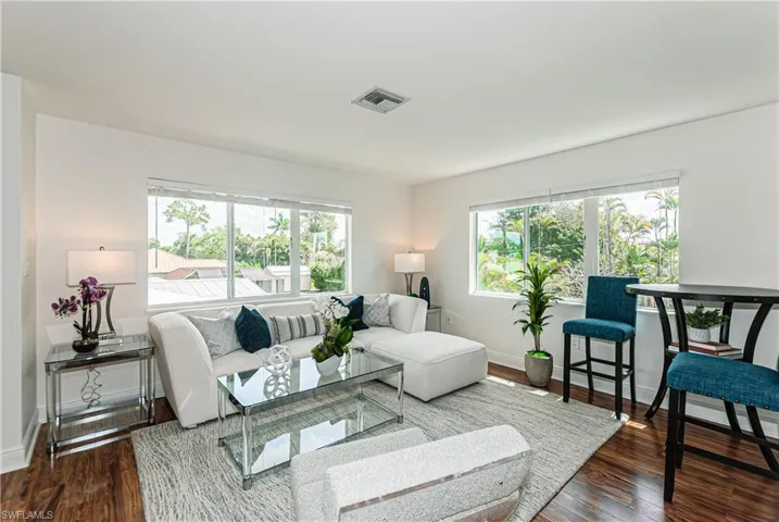 Living area with plenty of natural light and dark wood finished floors