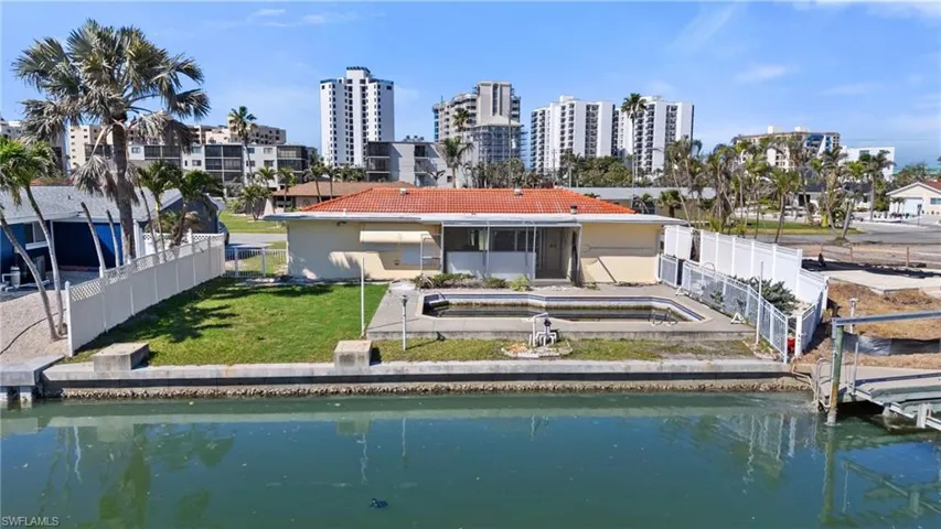Rear view of house featuring a yard, a view of city, and fence  - Virtually Edited Image