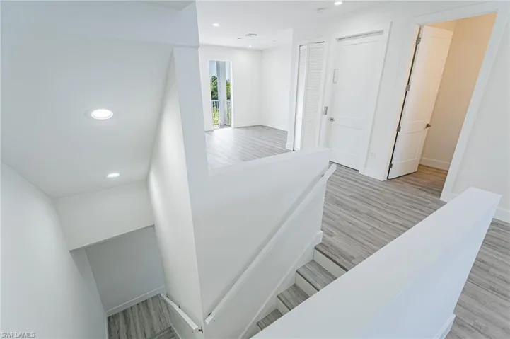 Stairs featuring recessed lighting and wood finished floors