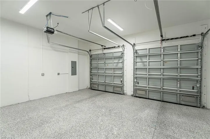 Garage featuring electric panel and a garage door opener