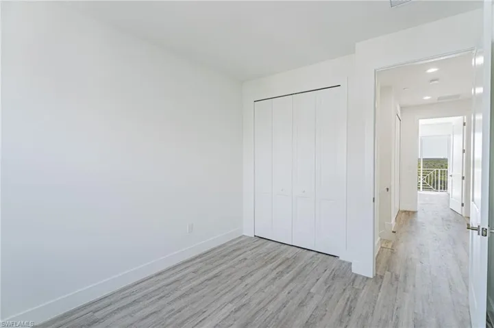 Unfurnished bedroom featuring wood finished floors, a closet, and recessed lighting