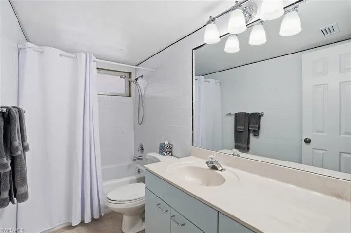 Full bathroom with shower / tub combo with curtain and vanity - Virtually Edited Image