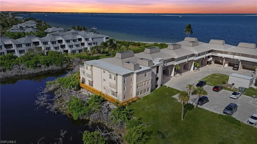 Aerial view at dusk of a water view and a view of apartment building / complex - Virtually Edited Image