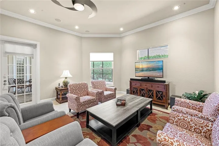 Living room with hardwood / wood-style floors and crown molding