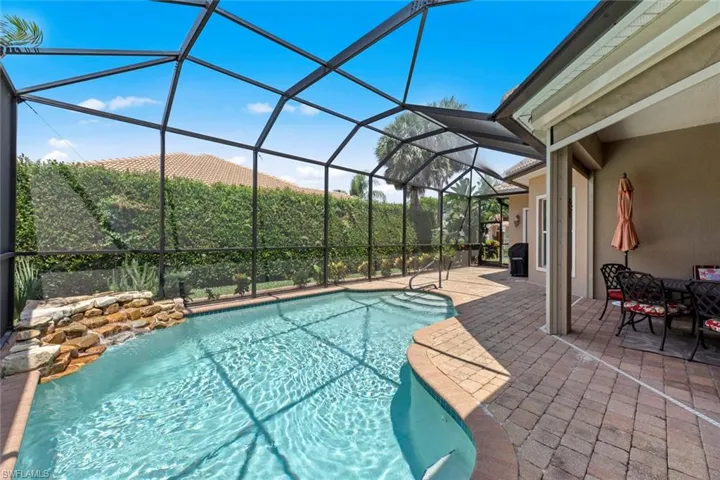 View of swimming pool with a patio and glass enclosure