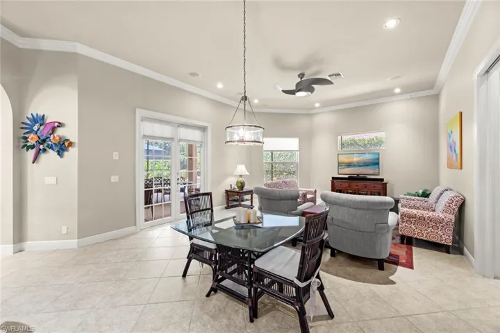 Tiled dining space featuring crown molding and ceiling fan