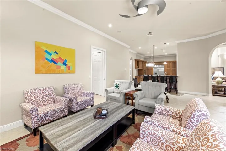 Tiled living room featuring ornamental molding and ceiling fan