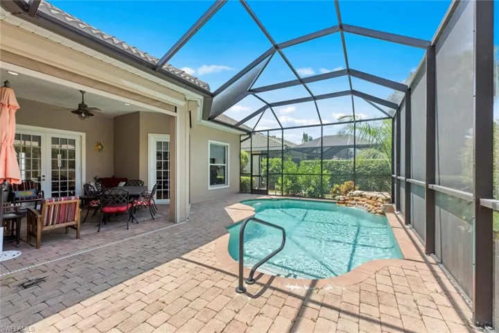 View of swimming pool with ceiling fan, a lanai, and a patio area