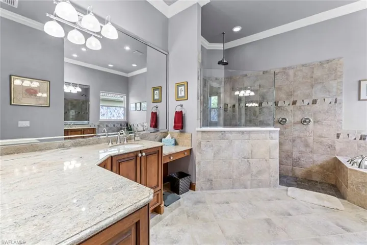 Bathroom featuring tile flooring, ornamental molding, oversized vanity, and independent shower and bath