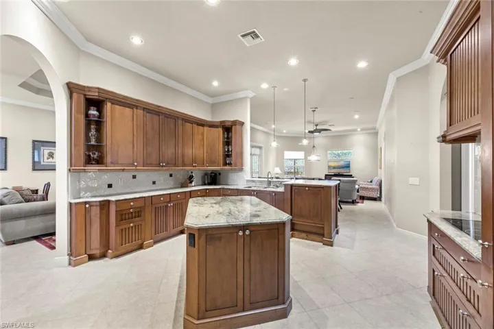 Kitchen with a kitchen island, ornamental molding, tasteful backsplash, and kitchen peninsula
