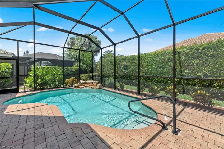 View of pool featuring glass enclosure and a patio