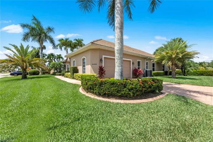 View of side of property with central AC, a garage, and a yard