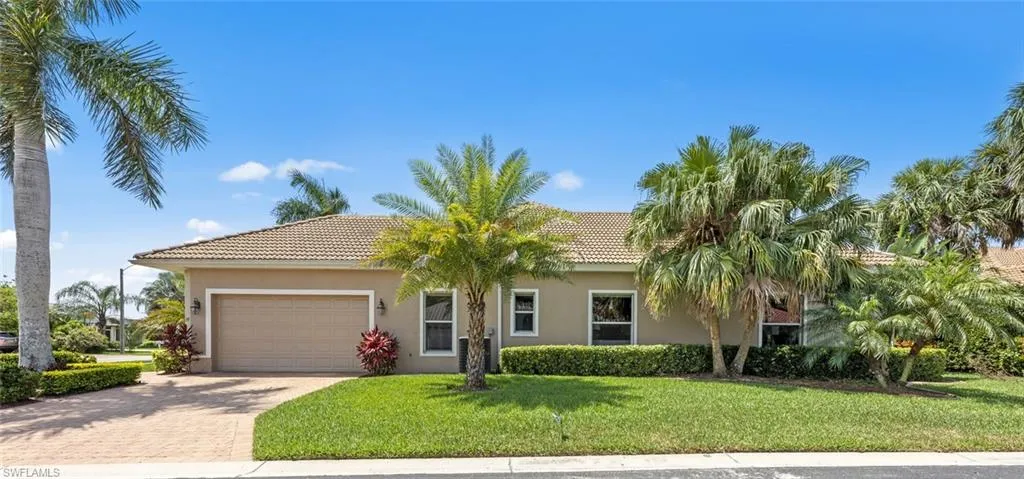 View of front of home with a garage and a front lawn