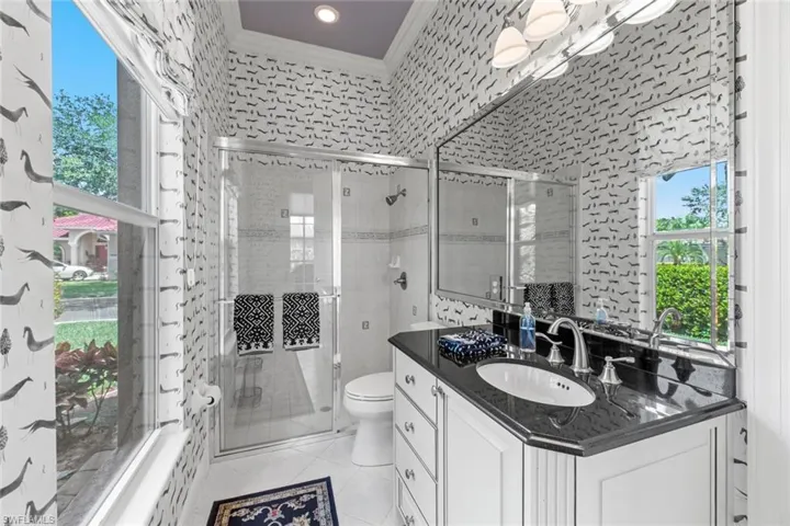 Bathroom featuring tile flooring, vanity, toilet, and crown molding