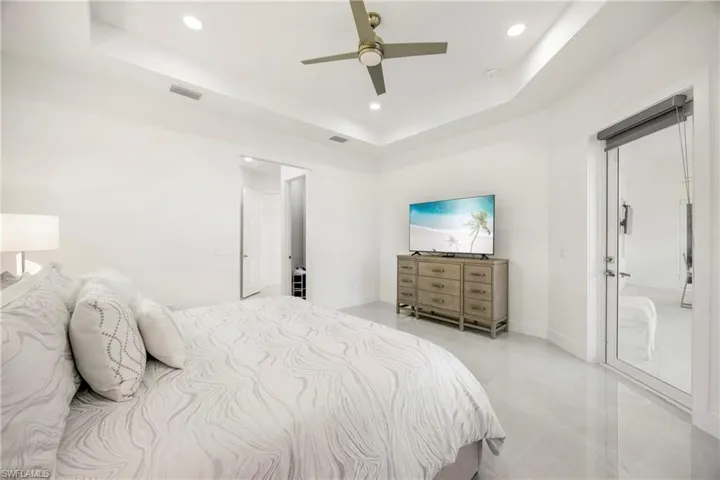 Bedroom featuring a tray ceiling, ceiling fan, and recessed lighting