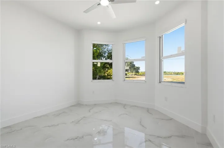 Empty room featuring light marble finish floors, recessed lighting, and ceiling fan