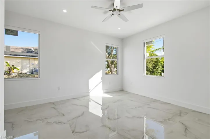 Unfurnished room featuring light marble finish flooring, plenty of natural light, recessed lighting, and ceiling fan