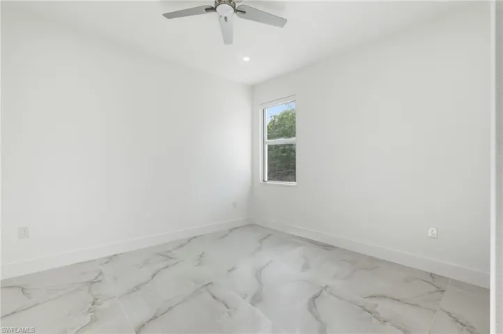 Spare room with baseboards and light marble finish floors