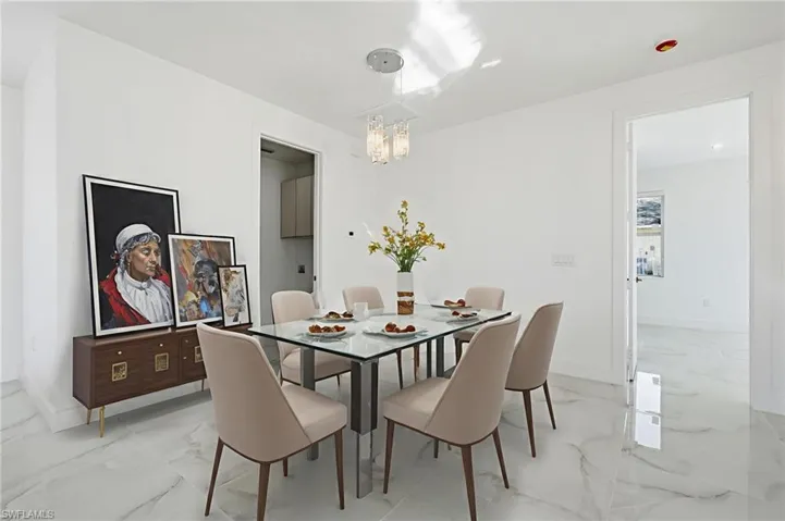 Dining room with light marble finish flooring and a chandelier