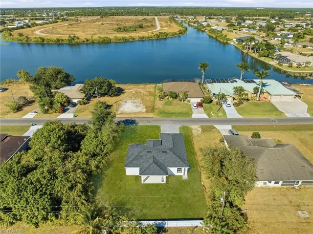 Aerial perspective of suburban area featuring a nearby body of water