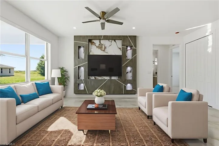 Living area featuring finished concrete floors, ceiling fan, and recessed lighting