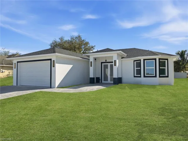 View of front of house with a front lawn, driveway, stucco siding, and roof with shingles